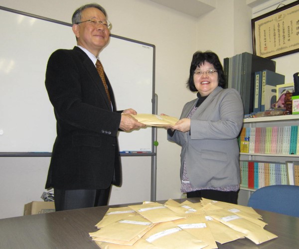 ベルマークを寄贈する岩橋尚美さん(右)と受け取る宮田謙一常務理事