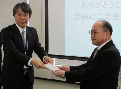 セイコーエプソンの濱取締役（左）から寄贈マーク証明書が財団の野中事務局長に手渡されました