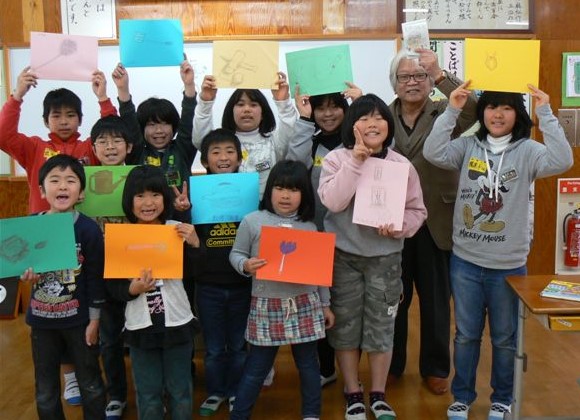仕上げた「さぐり絵」を掲げて記念写真＝いずれも佐賀県唐津市の高島小学校で