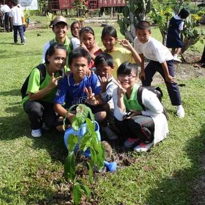 初めての植林で大切に苗木を植える子ども＝マレーシア・サバ州ラナウのアリ小学校で