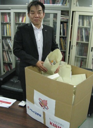 段ボール箱いっぱいのベルマークを届けたユタカファーマシー取締役の神野剛さん＝名古屋市中区の朝日新聞名古屋本社で