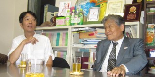 財団事務所で歓談する見栄晴さん（左）と浅井企画の川岸咨鴻専務取締役