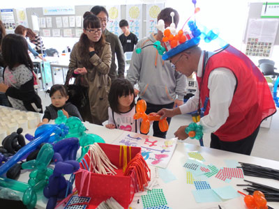 仕分けをしてくれた子どもたちに、風船をプレゼントする昼ボラ隊メンバー＝いずれも愛知県刈谷市のデンソー本社