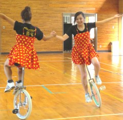 児童たちに一輪車を指導する小山美由紀さん(右)と浮谷奈菜さん(左)の2人=8月3日、同小学校で