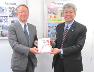 《写真》目録を手渡す阪田斉弘本部長（右）。左は財団の宮田謙一常務理事