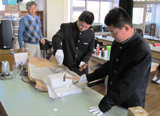 ドライアイスを割る生徒。後ろが平松和彦さん