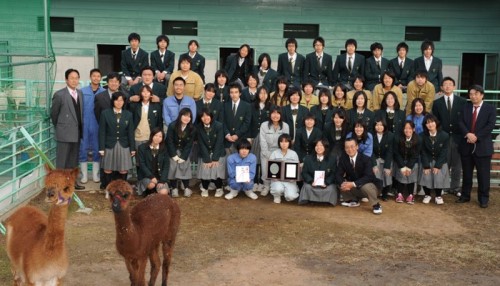 最近アメリカの牧場主から贈られた２頭のアルパカと一緒に記念写真に収まる「ふれあい動物部」のみなさん