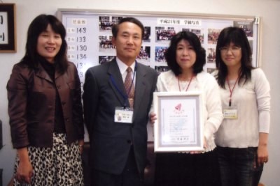 感謝状を手に500万点達成を喜ぶ桑原小学校PTAの松本真美会長(右から2人目)、高岡麻子学校教育部長(右端)と鈴木康二校長(左から2人目)、ボランティア活動委員会担当の窪田安代教諭(左端)