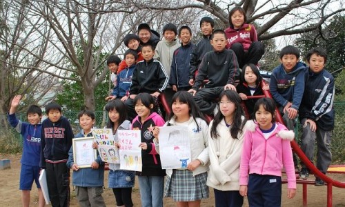 購入した校庭遊具グルリンに集まったベルマーク委員会。協力を呼びかけたポスターを手にする子どもも
