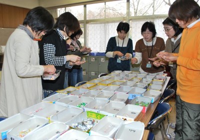 岩間淳子部長(右から3人目)を中心に、ベルマークを協力会社ごとに仕分けるPTA事業部のお母さん方=いずれも千葉県鎌ケ谷市の道野辺小学校で