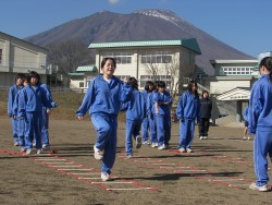 足を上げ手を振って走るリズムを習う生徒。後には雄大な岩手山が間近見えました