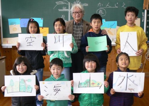 みんな自信満々、作品を手に喜田川さんと記念撮影＝いずれも大分県日田市の出野小学校で