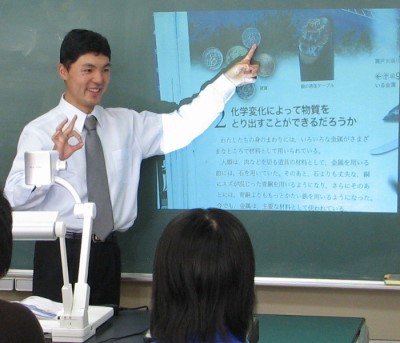 黒板に映し出した教科書を示しながら授業する牛山先生。左手前が教材提示装置